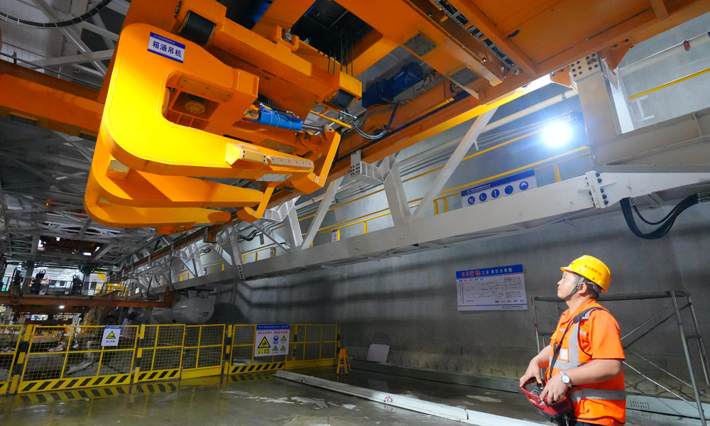 針對(duì)首次在350公里高鐵隧道使用“整體全預(yù)制箱涵”，項(xiàng)目團(tuán)隊(duì)升級(jí)優(yōu)化盾構(gòu)機(jī)箱涵吊裝設(shè)備，實(shí)現(xiàn)箱涵件自動(dòng)抓取、一鍵調(diào)平工藝，將極大節(jié)省后續(xù)同步施工量，減少安全隱患，提高工程質(zhì)量和效率。圖為建設(shè)者正在操作箱涵吊機(jī)。