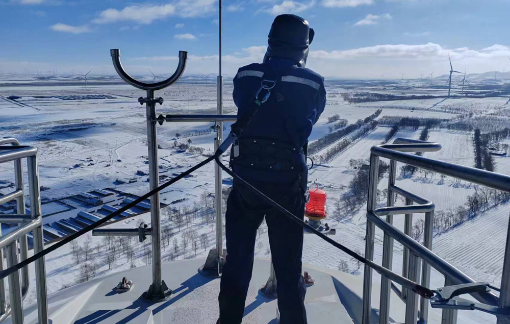 近期，寒潮天氣持續(xù)影響多地。東方電氣集團(tuán)持續(xù)推動(dòng)能源工程項(xiàng)目進(jìn)度，做好項(xiàng)目現(xiàn)場(chǎng)保障服務(wù)，助力能源保供。圖為在河北省馬神梁風(fēng)電項(xiàng)目現(xiàn)場(chǎng)，東方電氣集團(tuán)現(xiàn)場(chǎng)調(diào)試人員站在高達(dá)百米高的風(fēng)機(jī)上檢查風(fēng)速儀和風(fēng)向標(biāo)，確保風(fēng)機(jī)安全運(yùn)行。