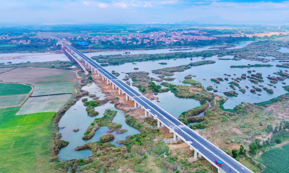 針對旅游公路建設點多線長、作業面廣、影響因素多等困難，項目團隊充分利用“BIM智慧建造+無人機航測技術”，將數字化設計和精細化相結合，縮短了施工工期，提高了施工質量；采用全自動滑模機進行混凝土水溝施工，成品外觀平順，強度、結構尺寸等均滿足設計要求，降低了施工成本，減少了環境污染，實現了智慧建造與綠色工地的高度統一。圖為海南環島旅游公路昌化江大橋。