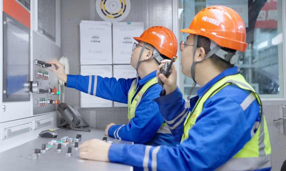 穗莞深城際機前段工程位于粵港澳大灣區廣深港城鎮發展帶與深圳市西部發展帶內，是大灣區城際鐵路網廣深主軸的重要組成部分，建成通車后將進一步提升穗莞深城際鐵路功能，對完善粵港澳大灣區城際網絡，實現區域經濟一體化發展具有重要意義。圖為技術人員在盾構機駕駛室里操作盾構機。