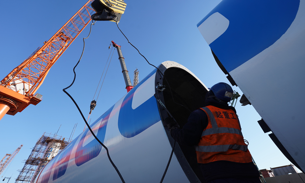 工作人員為船用風力旋筒助推系統塔筒的組裝掛載吊裝鎖具。杜春水 攝