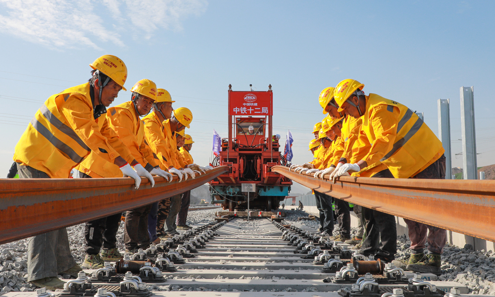 杭溫高鐵建成運營后，杭州、金華、臺州、溫州等地的仙華山、仙居、楠溪江等豐富的旅游資源將串聯成線，沿線仙居、磐安、東陽、浦江等地將正式邁入高鐵時代，對于推進鐵路基礎設施聯網、補網、強鏈，打造“軌道上的長三角”，構建浙江省“1小時交通圈”，便利沿線人民群眾出行，促進旅游資源開發和產業發展，助力浙江高質量發展建設共同富裕示范區和長三角一體化高質量發展等具有重要意義。圖為鋪軌機作業施工現場。