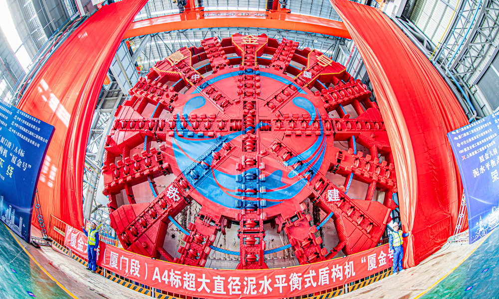 近日，由中國鐵建所屬中鐵十四局參與聯(lián)合打造的超大直徑泥水平衡盾構機“廈金號”在江蘇南通下線。該盾構機將應用于廈門至金門大橋（廈門段）主線隧道工程施工。該隧道是福建省在建最大直徑盾構公路隧道。圖為“廈金號” 盾構機下線現(xiàn)場。