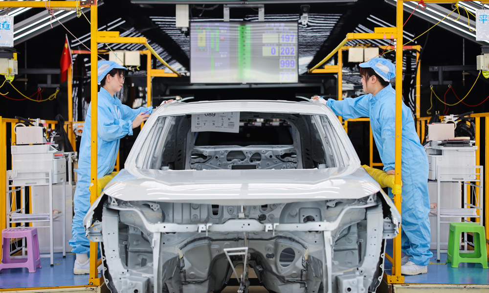 工作人員在位于天津市的一汽豐田涂裝車間檢查車身頂蓋漆面。