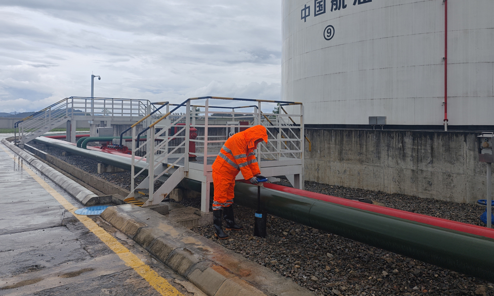 中國航油貴州分公司業務油庫值班人員在暴雨天巡查儲油罐區。