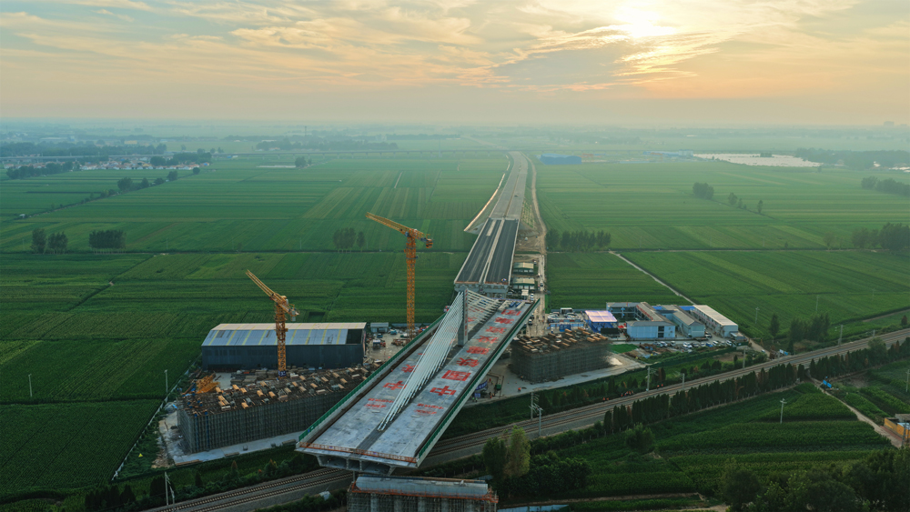 這座轉體橋主跨100米、邊跨70米，重量達23500噸，歷時40分鐘逆時針旋轉后精準就位，創下山東省首個跨鐵路不對稱矮塔斜拉轉體橋紀錄，為項目2025年年底建成通車奠定了堅實基礎。圖為大橋轉體過程中。 