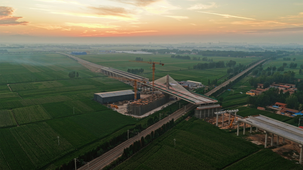 項目團隊首創應用“球鉸支座+智能牽引”系統，以兩臺連續千斤頂同步發力，精準驅動重量相當于1.5萬輛小汽車的橋體平穩轉動。同時運用BIM技術構建三維模型，并依托北斗實時監控系統，對橋梁轉角等關鍵參數實施毫秒級捕捉與動態調整。圖為大橋完成轉體施工。