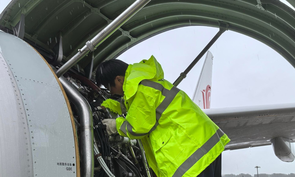 中航集團(tuán)機(jī)務(wù)人員手持專業(yè)工具，更換FMU（燃油計(jì)量單元）傳感器。