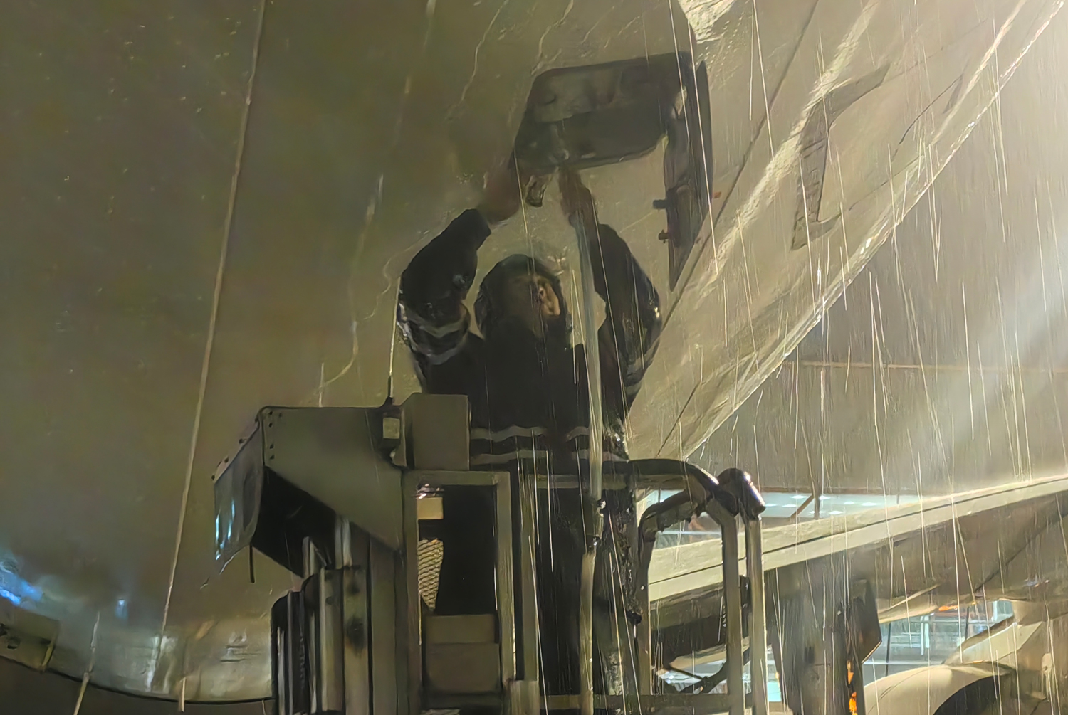 暴雨如注，中航集團(tuán)水車保障輔助操作員進(jìn)行加清作業(yè)。