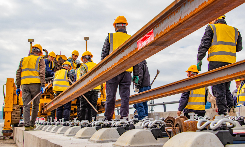 杭臺高鐵溫玉段是一條集路網、城際、旅游及經濟開發功能于一體的客運專線，主要承擔城際客流。項目建成運營后將填補玉環市鐵路空白，形成臺州“縣縣通鐵路、鐵路網全覆蓋”的交通新格局，對于加快打造浙江省1小時高鐵交通圈、完善區域路網結構布局、促進沿線文旅產業融合發展等具有重要意義。圖為施工人員在鋪設長軌。