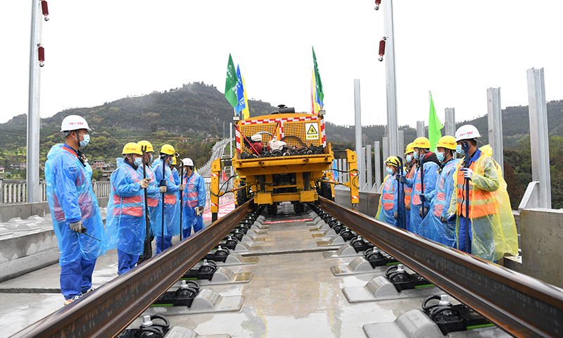 鄭萬(wàn)高鐵是我國(guó)“八縱八橫”高速鐵路網(wǎng)中沿江通道和呼南通道的重要組成部分。線路起于河南省鄭州市，止于重慶市萬(wàn)州區(qū)，新建線路全長(zhǎng)約818公里，設(shè)計(jì)時(shí)速350公里。圖為3月1日，在鄭萬(wàn)高鐵重慶段施工現(xiàn)場(chǎng)，施工人員進(jìn)行鋪軌前的準(zhǔn)備工作。(新華社記者 唐奕 攝)