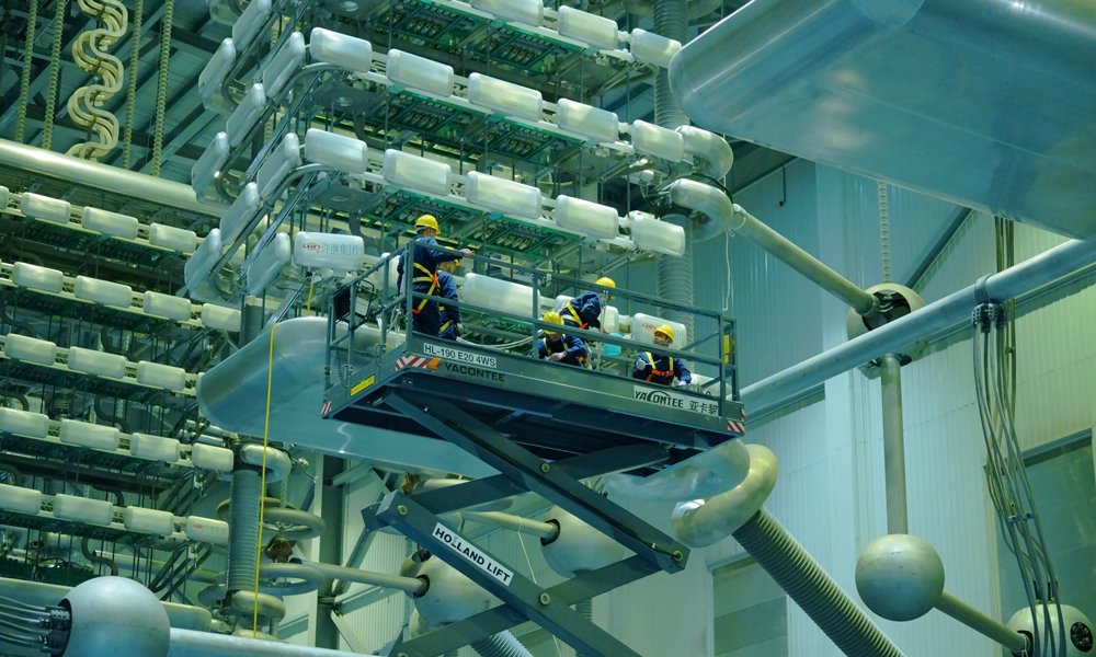 南方電網(wǎng)超高壓公司大理局檢修人員在極1高端閥廳使用升降車開展換流變套管斷復(fù)引工作。