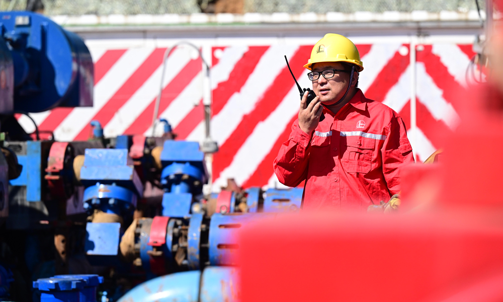 技術人員在全電動泵儲層改造現場指揮員工保養設備。