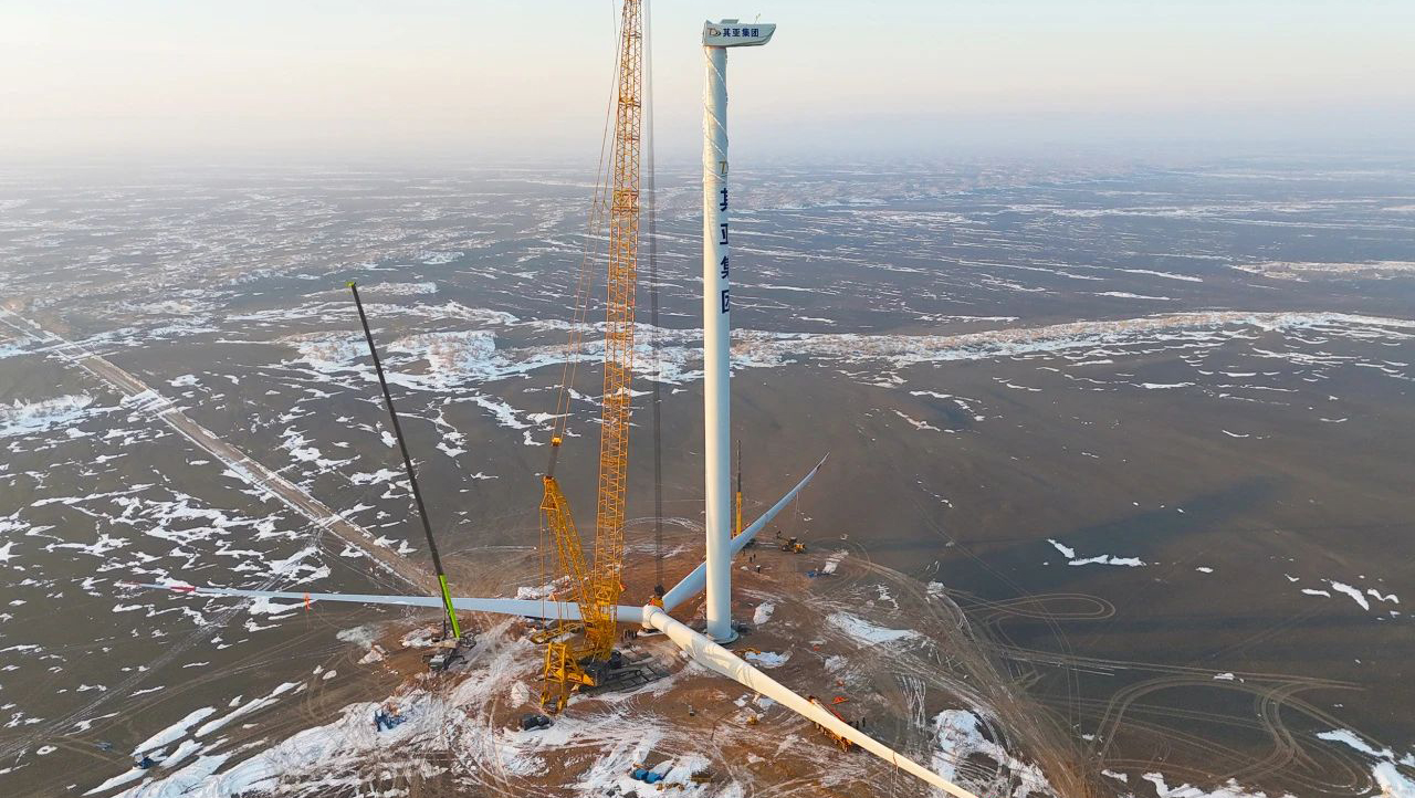 在新疆其亞的戈壁荒漠，氣溫達(dá)到零下26攝氏度，直徑220米、重達(dá)170余噸的巨大風(fēng)機(jī)扇葉，穩(wěn)穩(wěn)地落在150米高空基座上，新疆其亞260萬千瓦風(fēng)電項(xiàng)目在9天的有效吊裝時(shí)間內(nèi)，極速完成首臺(tái)風(fēng)機(jī)吊裝，努力讓綠色電能盡早輸送到千家萬戶。