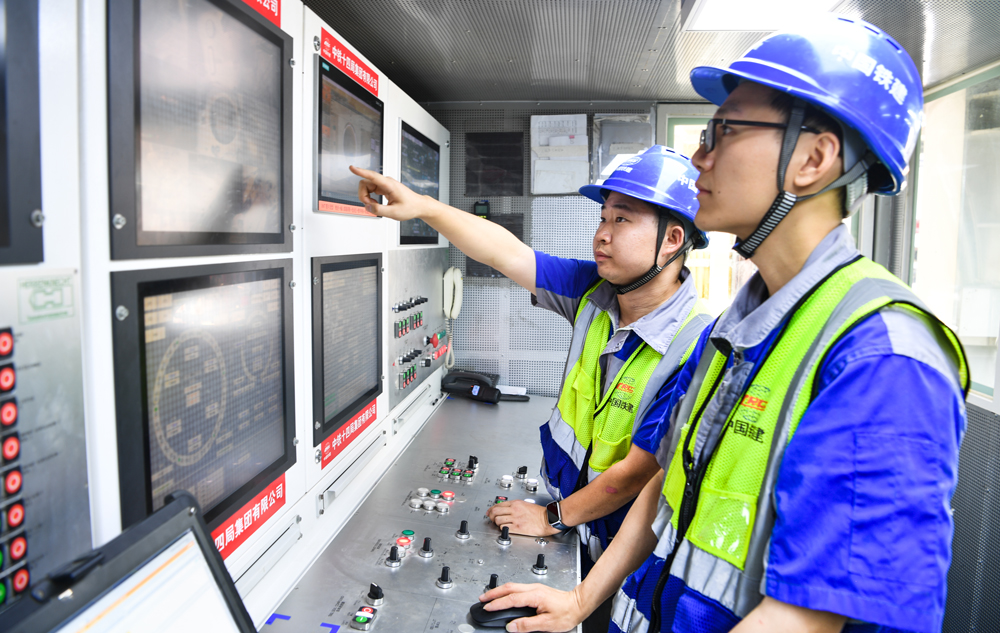 為打造精品隧道工程，項目團隊量身打造了“廈金號”超大直徑泥水平衡盾構機。該盾構機開挖直徑達16.15米，整機長度約165米，總重量約5100噸，是目前福建省最大直徑的盾構施工設備。圖為工程管理人員操作盾構機開始掘進。