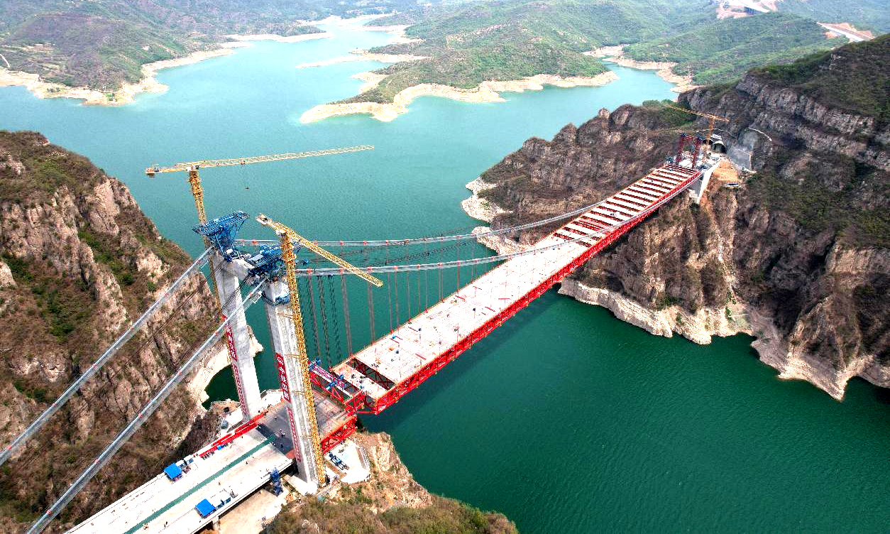 近日，中國(guó)中鐵旗下中鐵四局承建的世界首座獨(dú)塔單跨地錨式回轉(zhuǎn)纜懸索橋——濟(jì)新黃河大橋鋼桁梁全部吊裝完成。