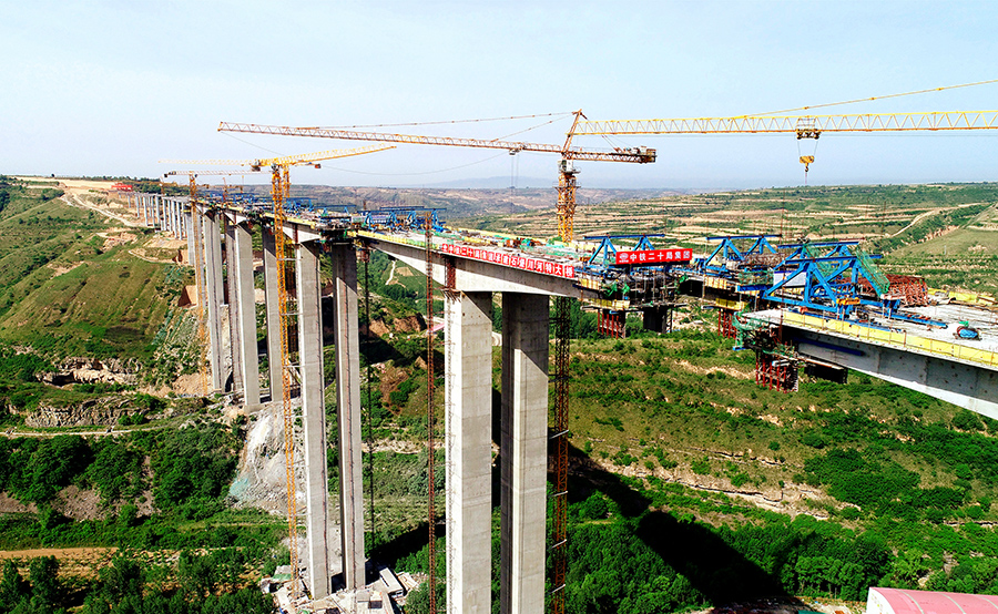 石堡川河特大橋全長1538米，最大橋高136.2米，主橋最大墩高129米。施工中采用液壓爬模技術，取得了3天一模（6米）施工紀錄，129米高的主墩僅用115天完成，比預計提前60天完工。圖為正在突擊施工的石堡川河特大橋。（劉斌斌 攝）