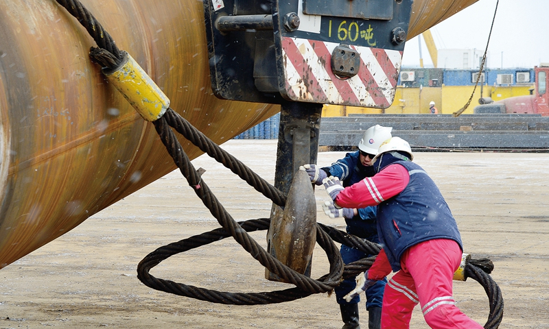 陸地遺留的工作海上干，海上的工作加班干。在海上施工期間，為爭取時效，項目組首先將腦筋動在生活支持、平臺送電、水源井啟用、海管通球等幾項重點任務的組織上，并在重點設備的調試上“盯梢”。臨近施工關鍵期，遠在異地的況昕、陳華、李云龍等人紛紛請纓助陣海上聯合調試，給早已身心疲憊的現場工程師岑亮、王從洋、付曉飛、關海崢等人提神鼓勁。圖為施工人員掛扣鎖具，進行導管架立片工作。