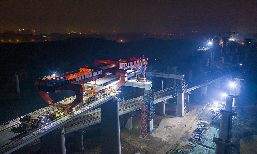 圖為作業(yè)人員正在架設常益高鐵黃橋大道特大橋上跨石長鐵路烏山聯(lián)絡線的箱梁。（彭特 攝）