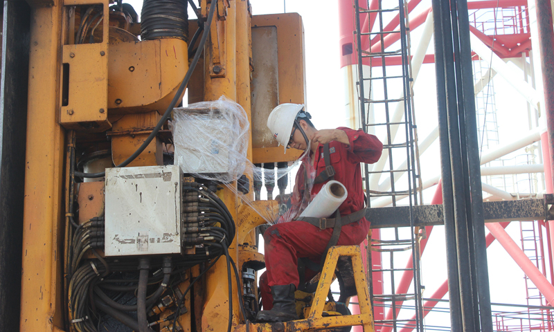 為應(yīng)對(duì)臺(tái)風(fēng)，近日中國(guó)海油所屬中海油服密切關(guān)注臺(tái)風(fēng)路徑信息和現(xiàn)場(chǎng)作業(yè)進(jìn)度，協(xié)調(diào)防臺(tái)資源。鉆井平臺(tái)提前周密部署，按照防臺(tái)預(yù)案開展現(xiàn)場(chǎng)設(shè)備工具固定、應(yīng)急設(shè)備設(shè)施檢查、艙室水密檢查、室外電氣設(shè)備防護(hù)等，將臺(tái)風(fēng)帶來(lái)的影響降到最低，確保生產(chǎn)作業(yè)順利開展，為沖刺年度生產(chǎn)經(jīng)營(yíng)目標(biāo)保駕護(hù)航。圖為“海洋石油931”鉆井平臺(tái)電氣師在撤臺(tái)前為頂驅(qū)電纜箱及電纜格蘭包裹防護(hù)膜，落實(shí)防風(fēng)雨措施，保障電氣線路安全。