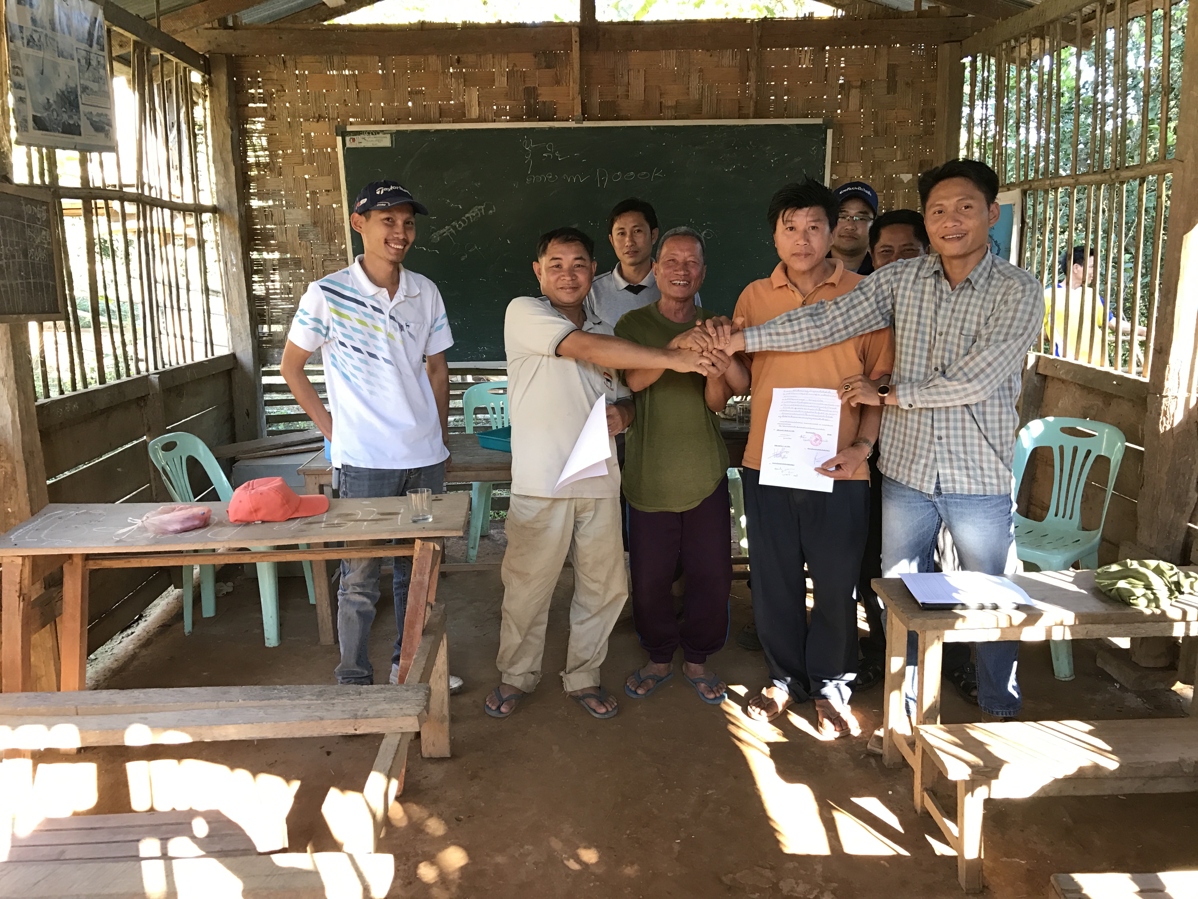 南塔河水電站的移民簽署同意搬遷協議，萬偉來拉（右一）與移民合影。.jpg